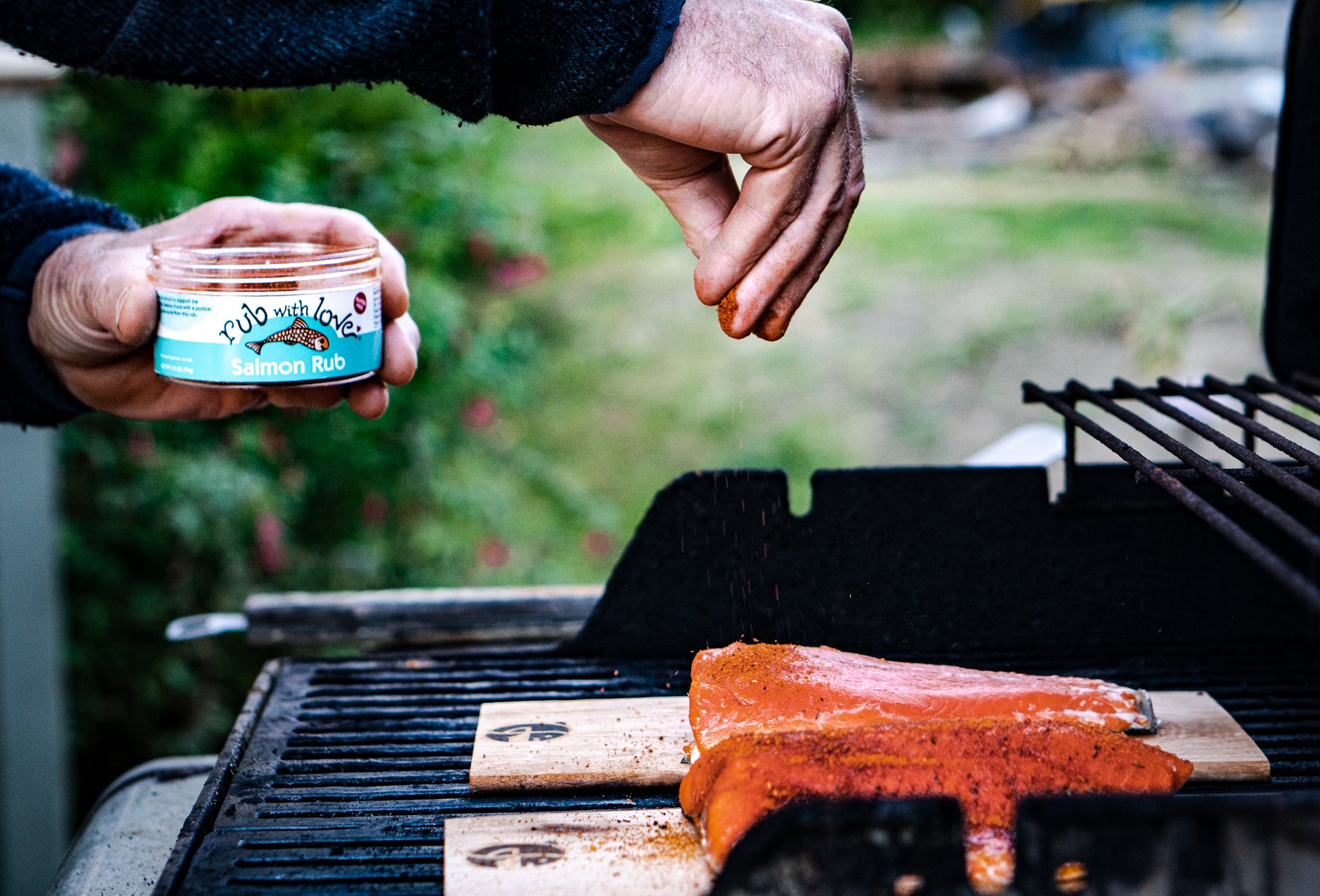 Image of person sprinking salmon rub on salmon