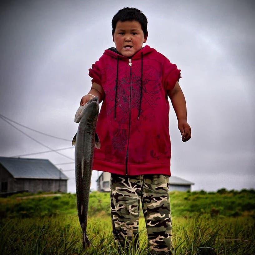 Alaskan native boy holding salmon